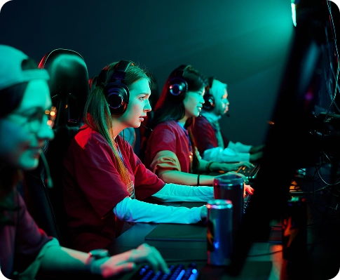 Vrouwelijke esports-spelers die gamingheadsets dragen en tijdens een esports-toernooi op pc’s tegen elkaar strijden, waarbij de nadruk ligt op teamwork en professioneel spel.