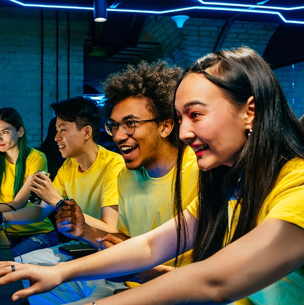 Een groep vrienden die samen esports speelt in een modern gamecentrum met RGB-computers, waarbij de nadruk ligt op teamwork en competitief online gamen.